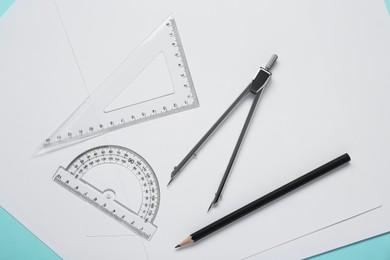 Photo of Different rulers, pencil, compass and paper sheets on turquoise background, flat lay