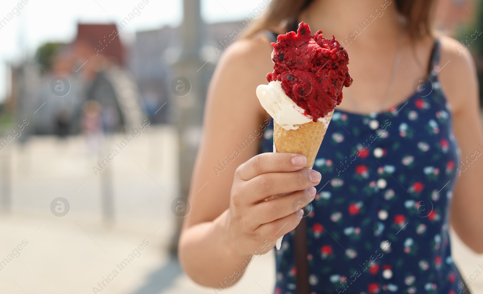 Photo of Young woman with delicious ice cream outdoors