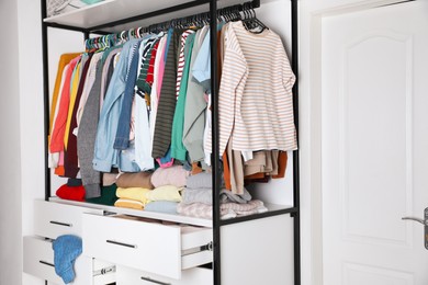 Rack with stylish women's clothes in room. Fast fashion