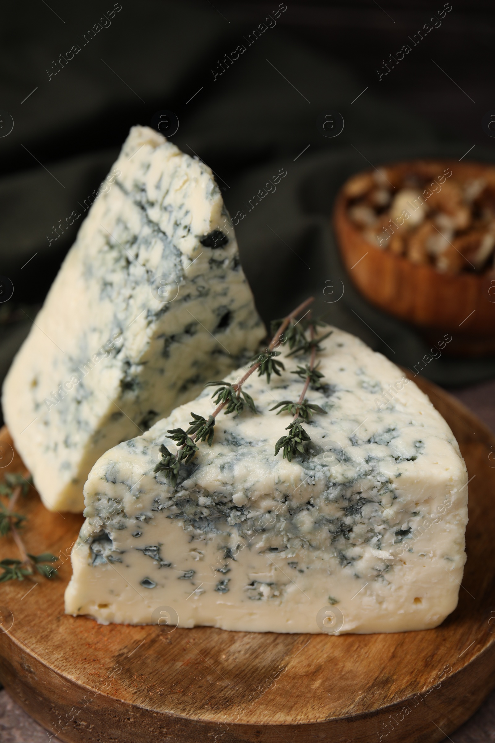 Photo of Tasty blue cheese with thyme on table, closeup
