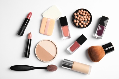 Flat lay composition with bottles of nail polish and different cosmetics on white background