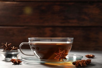 Aromatic tea with anise stars on light grey table