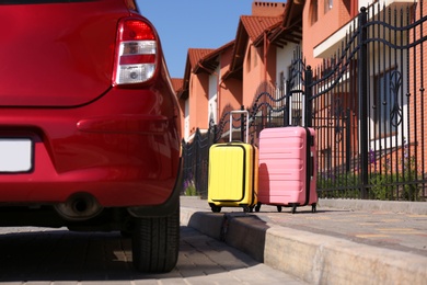 Photo of Color suitcases near family car in city. Summer vacation