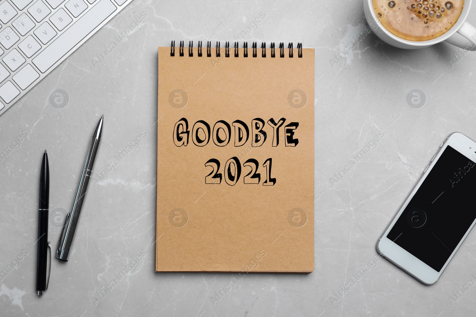 Image of Notebook with phrase Goodbye 2021, smartphone, keyboard, pens and cup of coffee on grey marble table, flat lay 