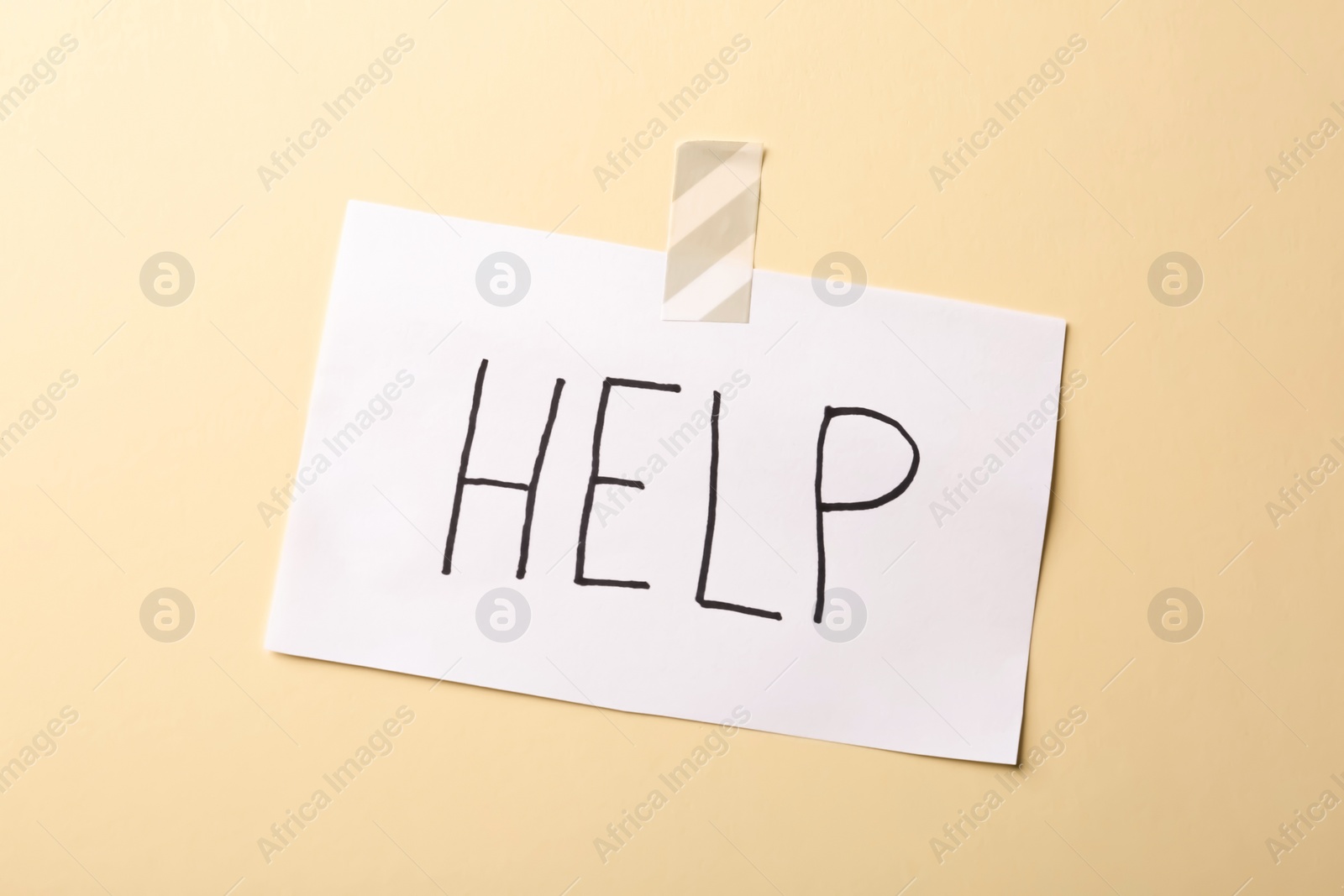 Photo of Paper note with word HELP on color background