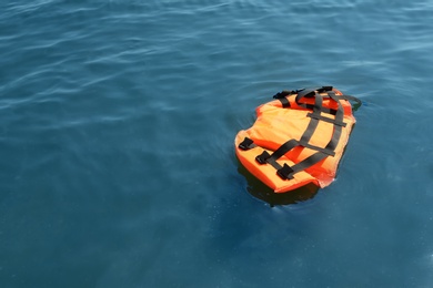 Photo of Orange life jacket floating in sea. Emergency rescue equipment