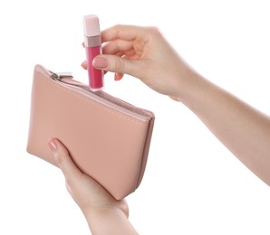 Woman putting lipstick into cosmetic bag on white background, closeup