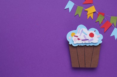 Birthday party. Paper cupcake and bunting flags on purple background, flat lay with space for text
