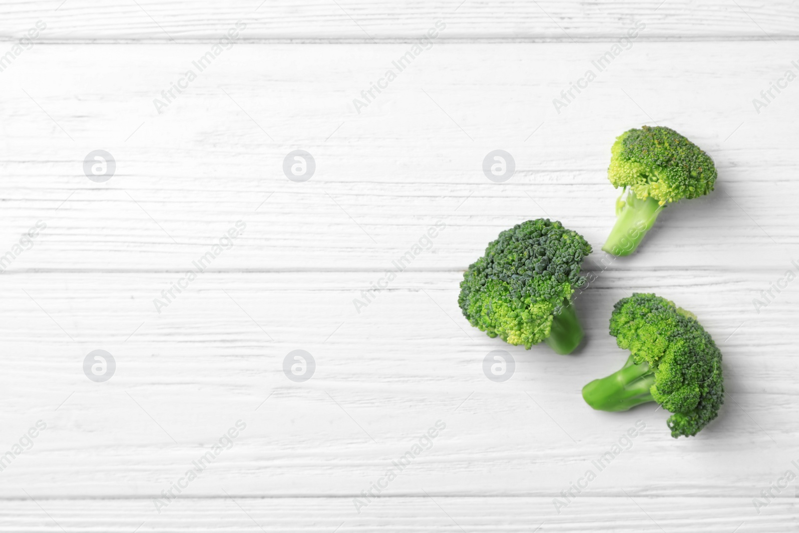 Photo of Fresh green broccoli on wooden background, top view