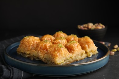 Photo of Delicious sweet baklava on black table, closeup