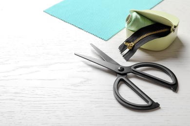 Set of tailoring accessories and fabric on light background