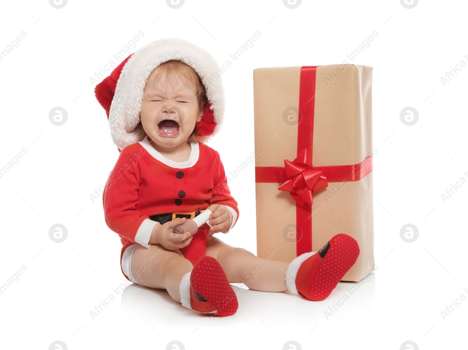 Photo of Cute little baby in Christmas costume and gift on white background