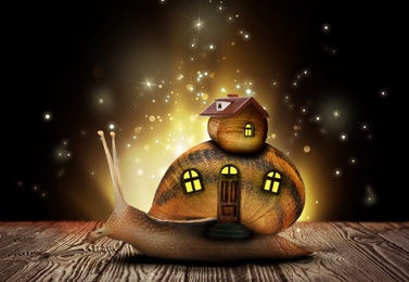 Image of Fantasy world. Magic snail with its shell house moving on wooden surface surrounded by fairy lights