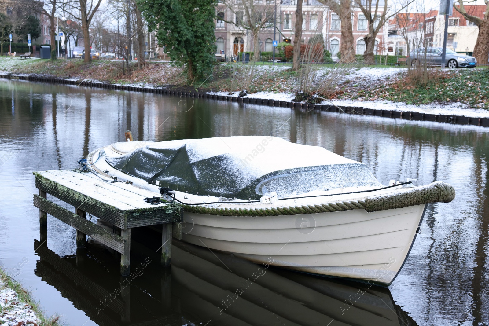 Photo of Water canal with moored boat on winter day