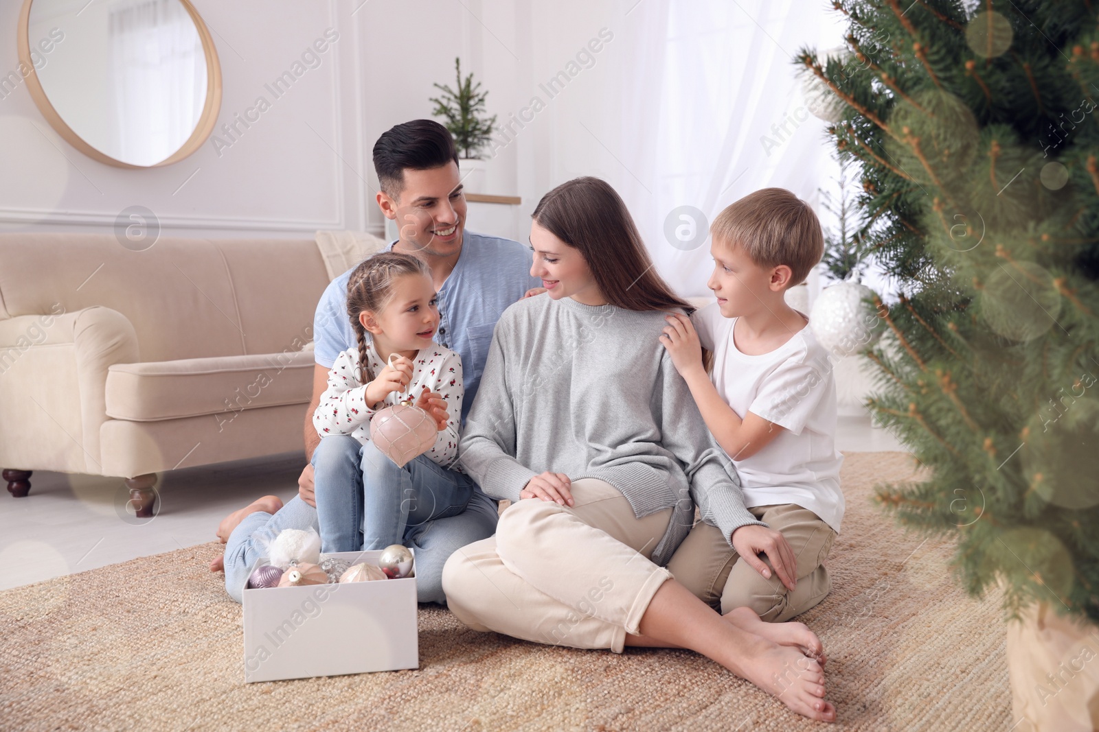 Photo of Happy family with cute children near Christmas tree together at home