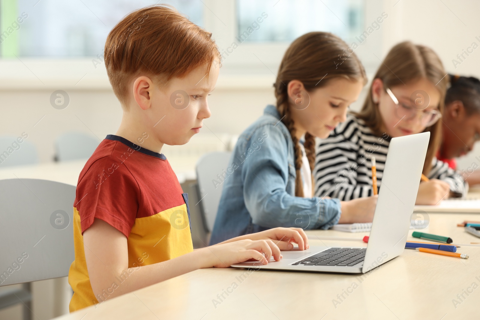 Photo of Cute children studying in classroom at school