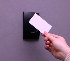 Photo of Woman opening magnetic door lock with key card, closeup. Home security