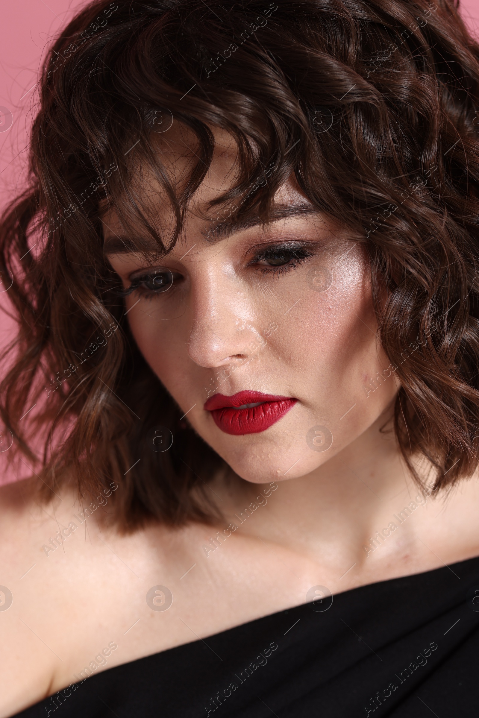 Photo of Portrait of beautiful young woman with wavy hairstyle on pink background