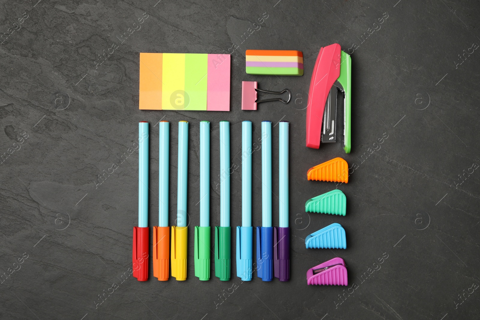 Photo of Flat lay composition with different school stationery on black stone table. Back to school
