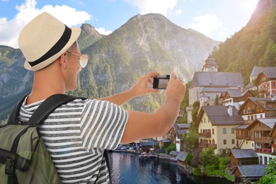 Image of Tourist with travel backpack taking photo during vacation trip