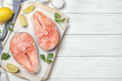 Photo of Flat lay composition with fresh raw salmon on white wooden table, space for text. Fish delicacy