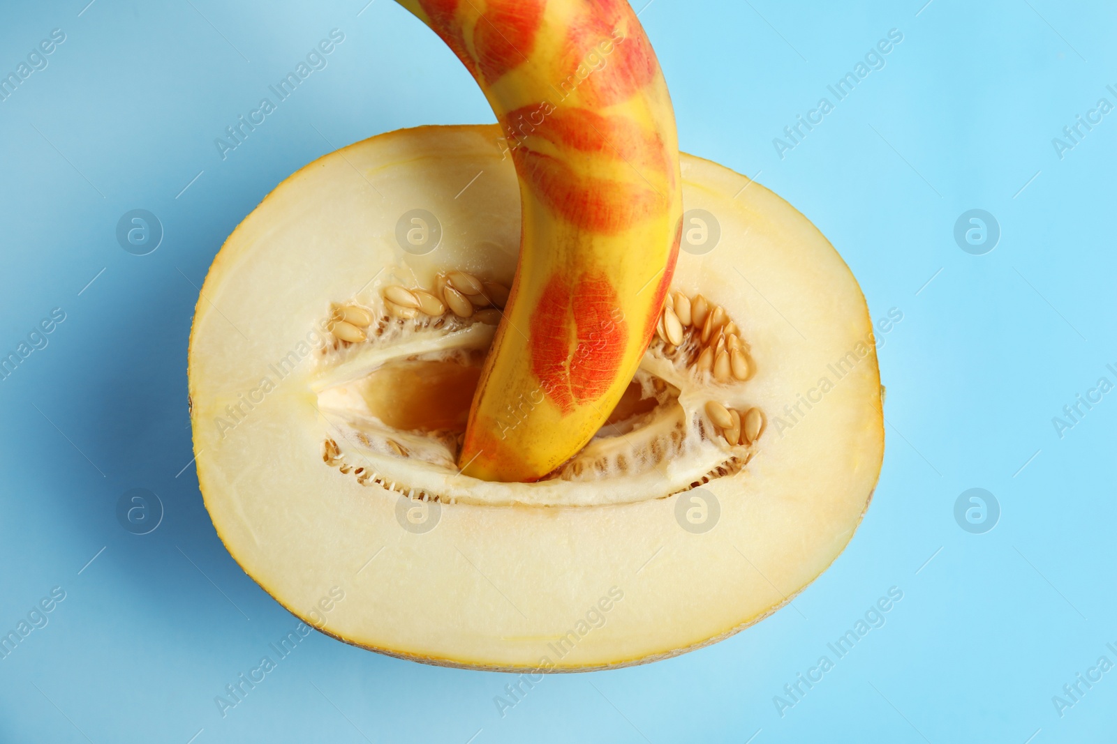 Photo of Flat lay composition with fresh banana and melon on blue background. Sex concept