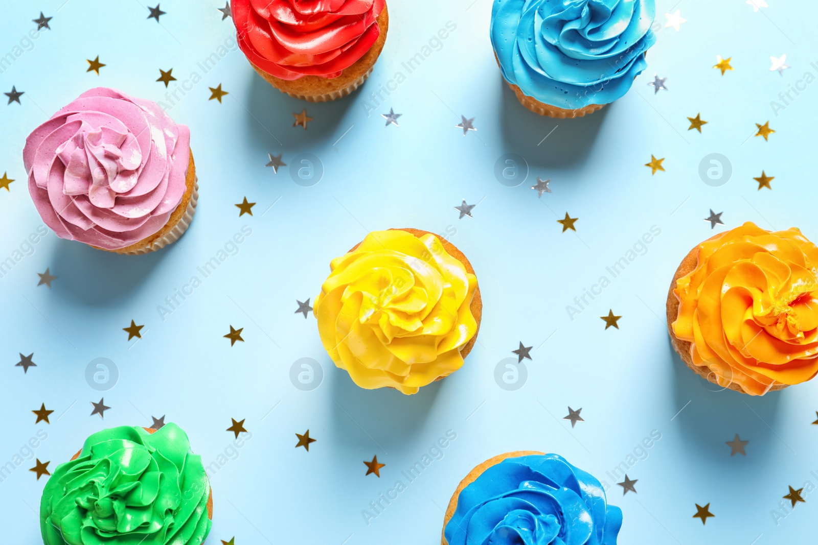 Photo of Flat lay composition with colorful birthday cupcakes on color background