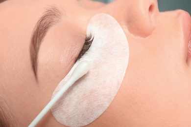 Photo of Young woman undergoing eyelash extension procedure, closeup