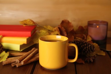 Photo of Composition with cup of hot drink and autumn leaves on wooden table