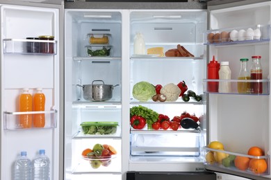 Open refrigerator full of different products indoors