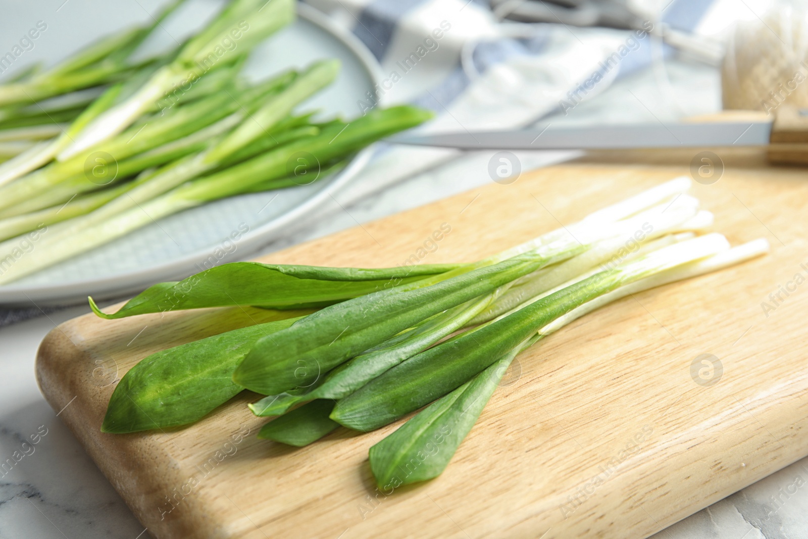 Photo of Board with wild garlic or ramson on table, closeup