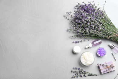 Photo of Flat lay composition of handmade soap bar with lavender flowers and ingredients on grey stone background. Space for text