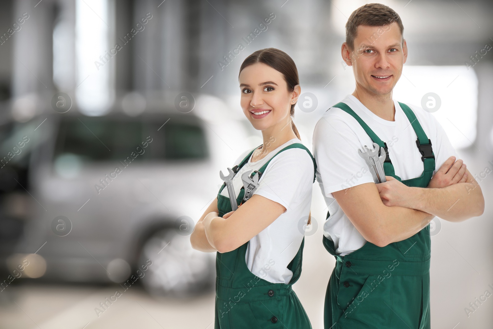 Image of Professional mechanics with wrenches at tire shop