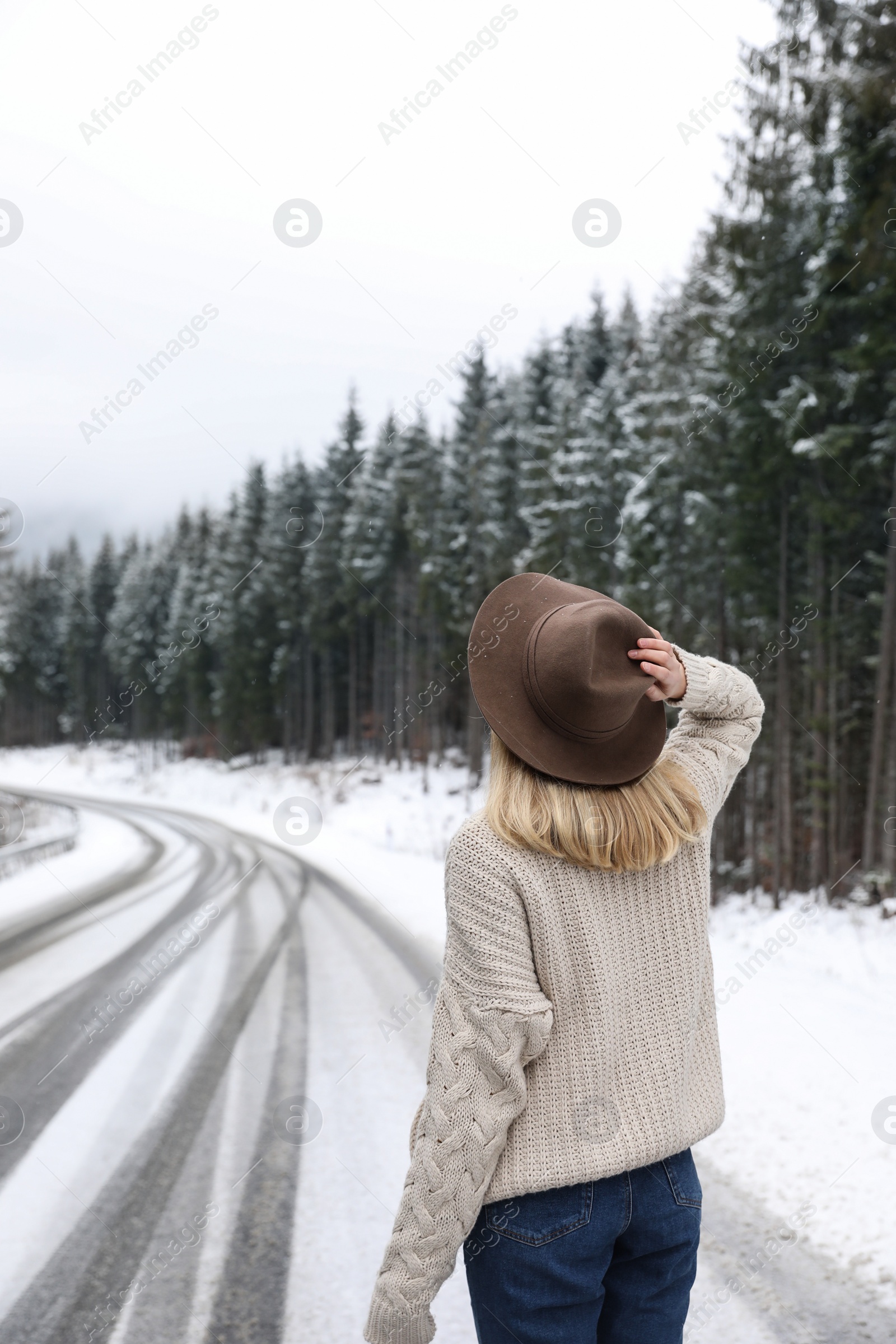 Photo of Young woman walking near snowy forest. Winter vacation