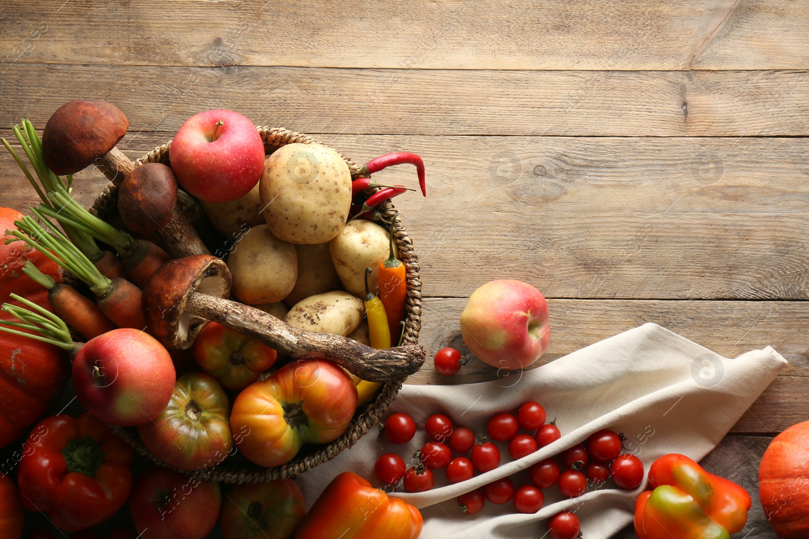 Photo of Basket with different fresh ripe vegetables and fruits on wooden table, flat lay. Space for text