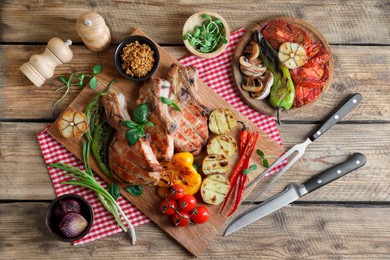 Photo of Delicious grilled meat and vegetables served on wooden table, flat lay