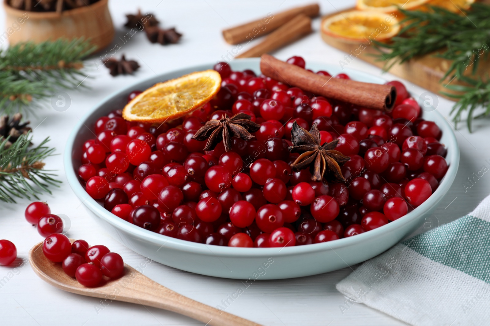 Photo of Fresh ripe cranberries and spices on white wooden table