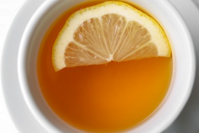 Photo of Cup with delicious immunity boosting tea and lemon, closeup