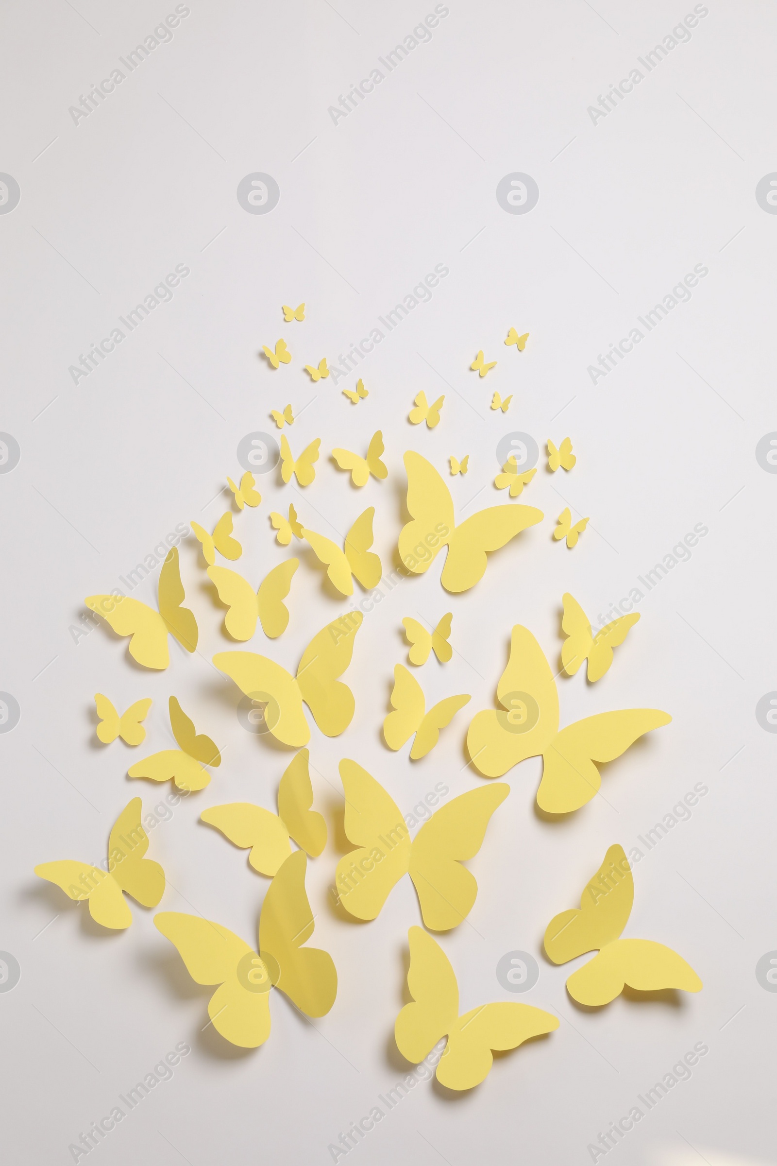 Photo of Yellow paper butterflies on white background, top view