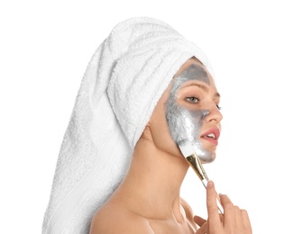 Photo of Beautiful woman applying silver mask on her face against white background