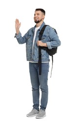 Man with backpack in denim clothes waving hand on white background