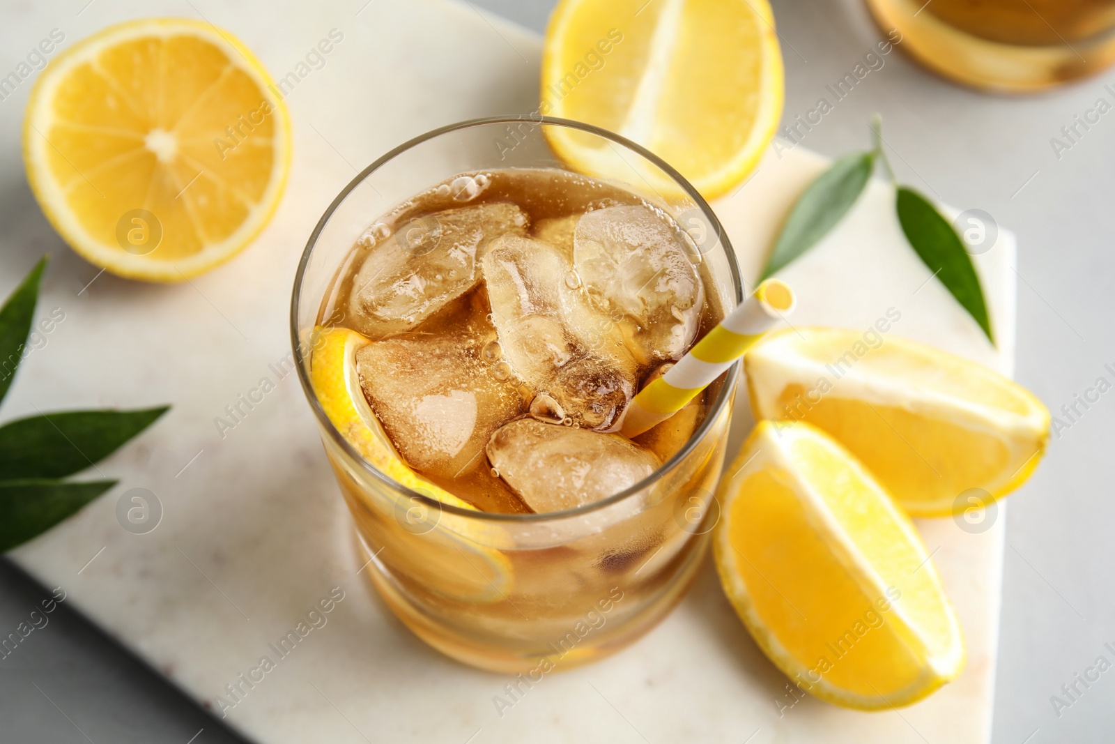 Photo of Glass of lemonade with ice cubes and fruit on table