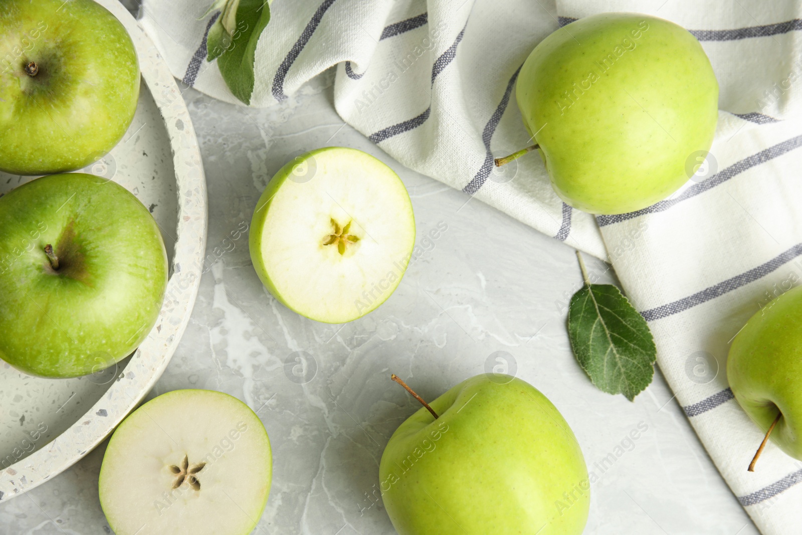 Photo of Flat lay composition of fresh ripe green apples on grey stone table