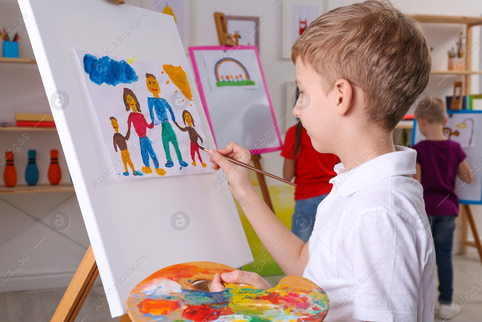 Photo of Cute little child painting during lesson in room