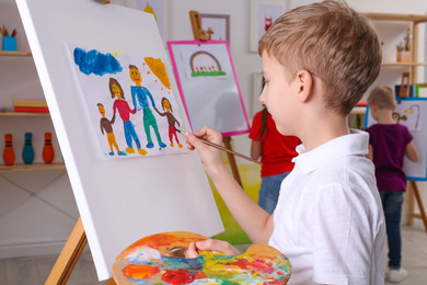 Cute little child painting during lesson in room