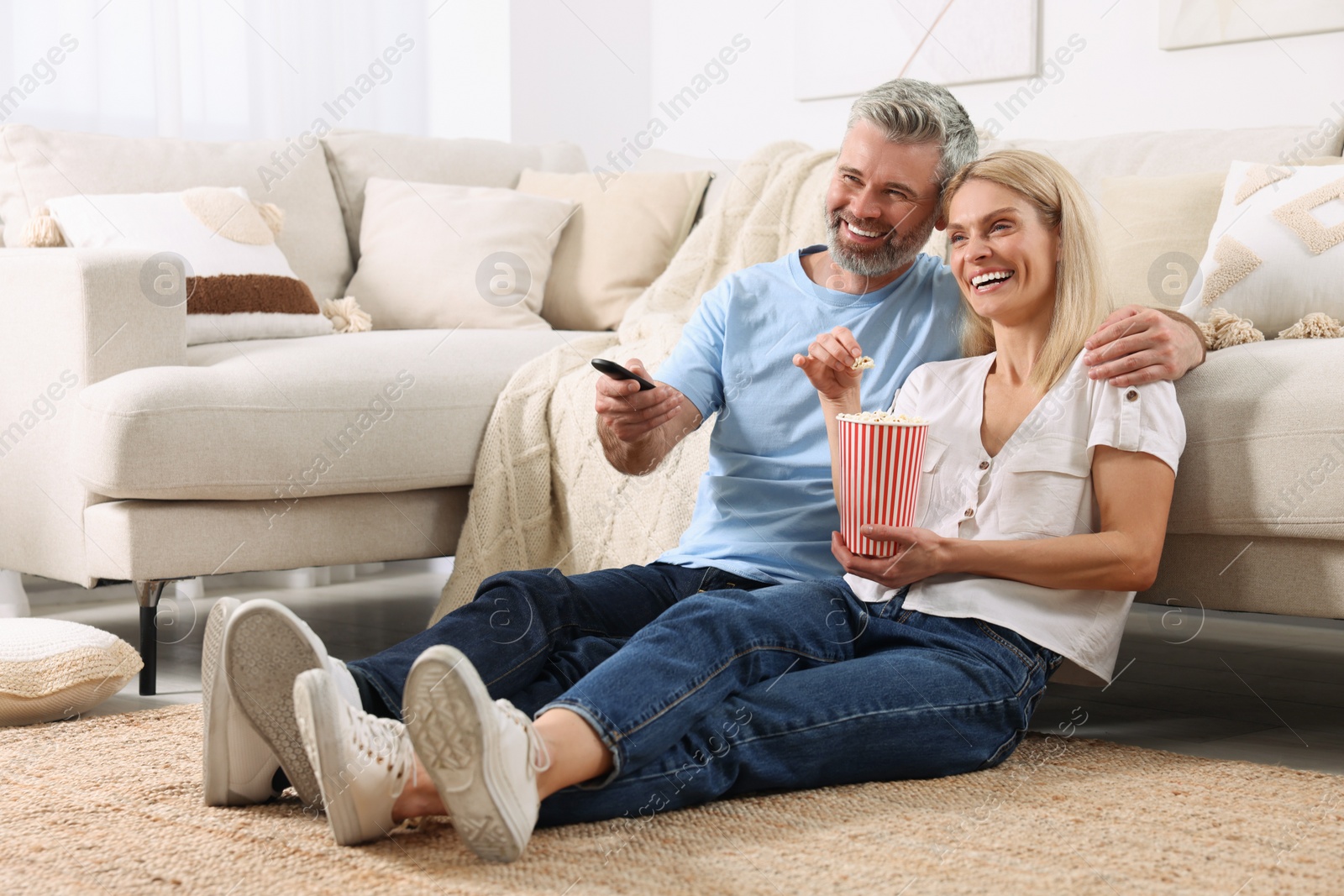 Photo of Happy affectionate couple with popcorn spending time together at home. Romantic date