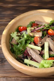 Delicious salad with beef tongue and vegetables on wooden table, closeup