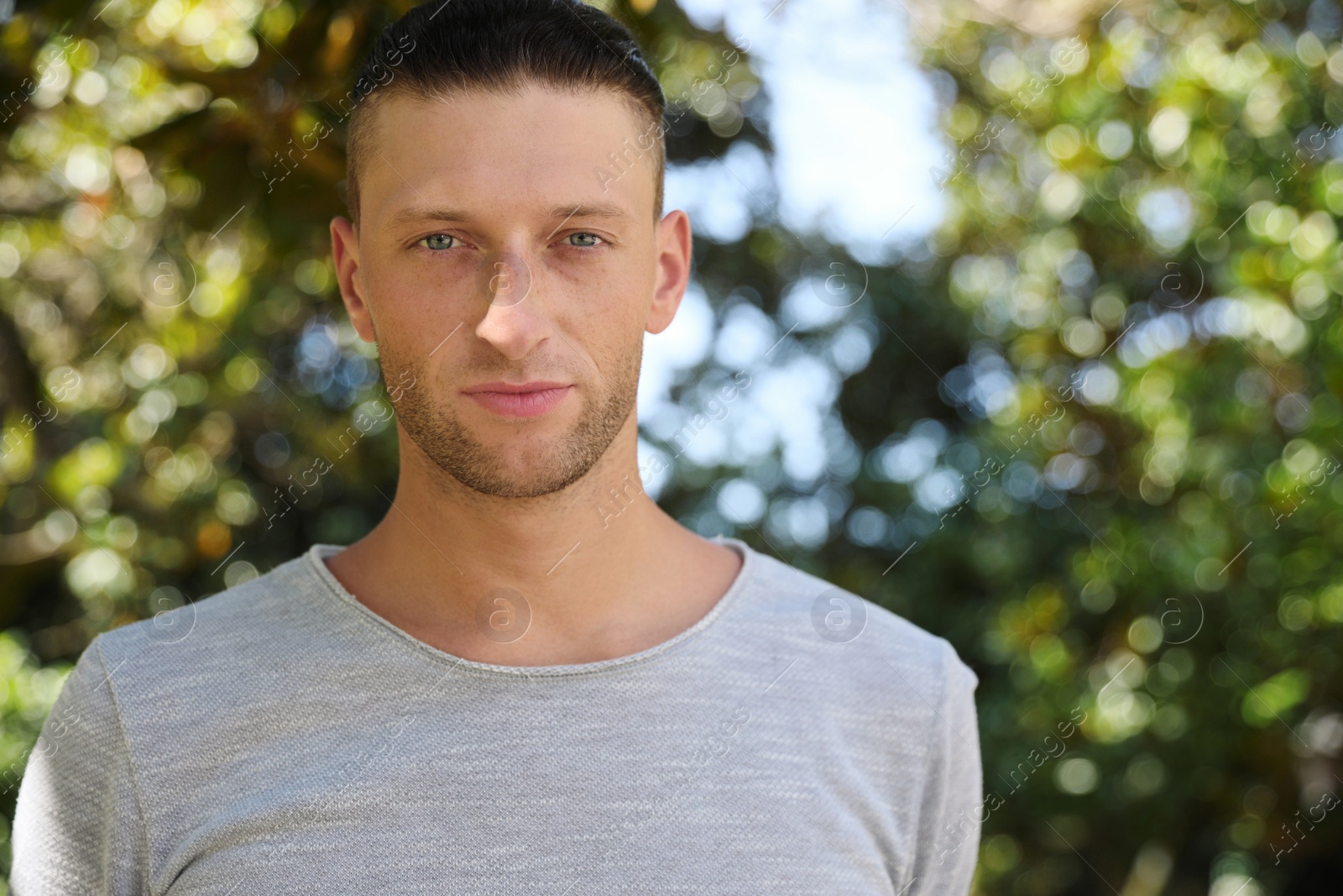 Photo of Portrait of handsome young man in park, space for text