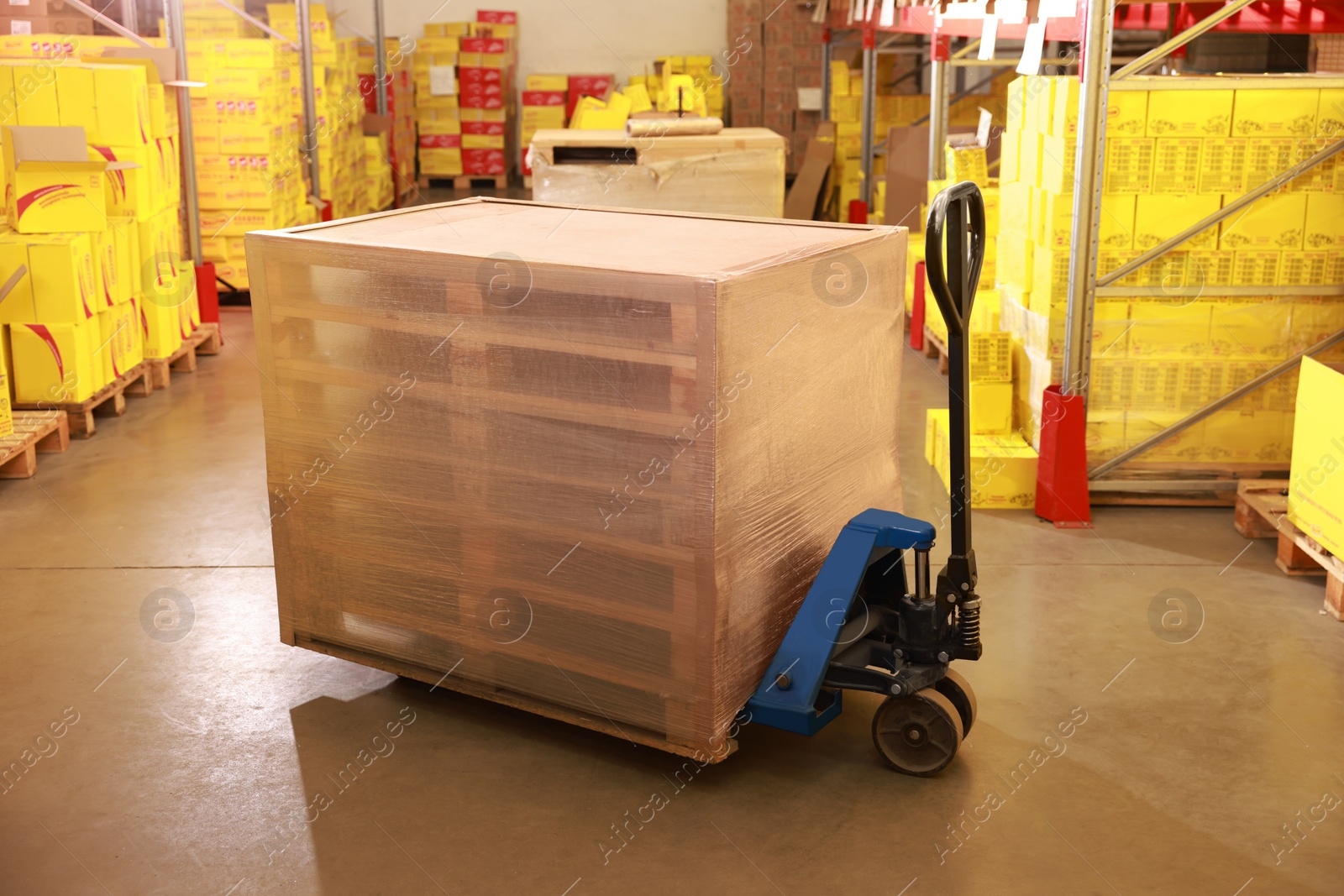 Image of Modern manual forklift with wrapped wooden pallets in warehouse