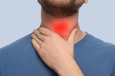 Image of Endocrine system. Man doing thyroid self examination on grey background, closeup